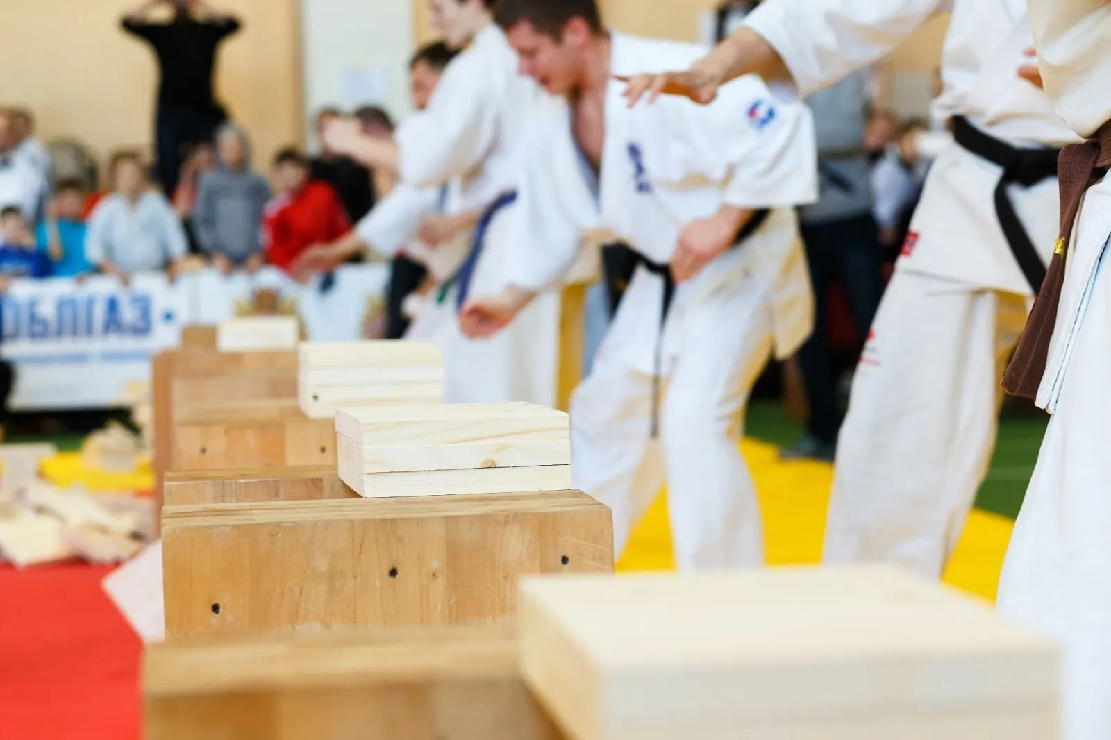 Alumnos de kárate rompiendo tablas en una competición de artes marciales